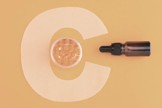 A tincture placed beside a bowl of tapioca balls against a peach-colored background